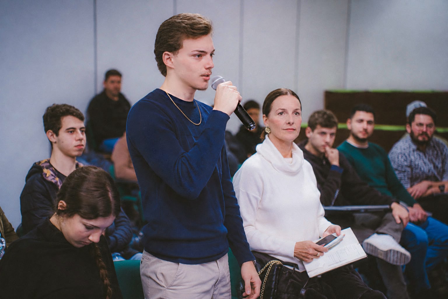 Lorenzo Arnold Müller em um ambiente de evento, segurando um microfone